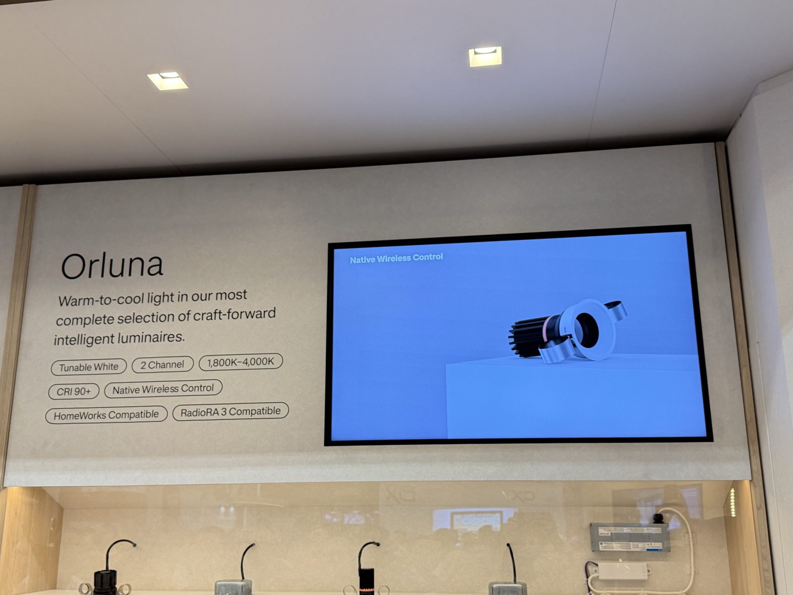Lutron Orluna intelligent lighting display at CEDIA Expo 2026 showing warm-to-cool tunable white specs and a downlight fixture on screen