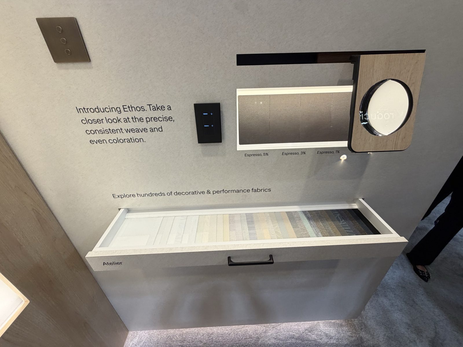 Lutron Ethos PVC-free shade fabric display at CEDIA Expo 2026 with a pull-out drawer of fabric swatches and Espresso 5, 3, and 1 percent opacity samples