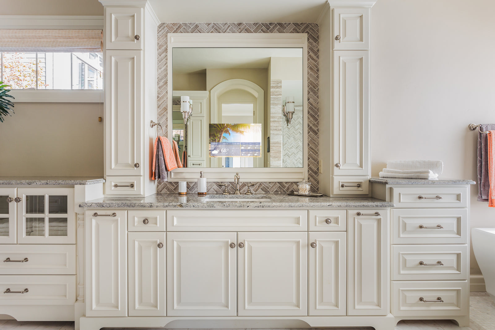 A framed S&eacute;ura vanity mirror with the television visible in the lower corner