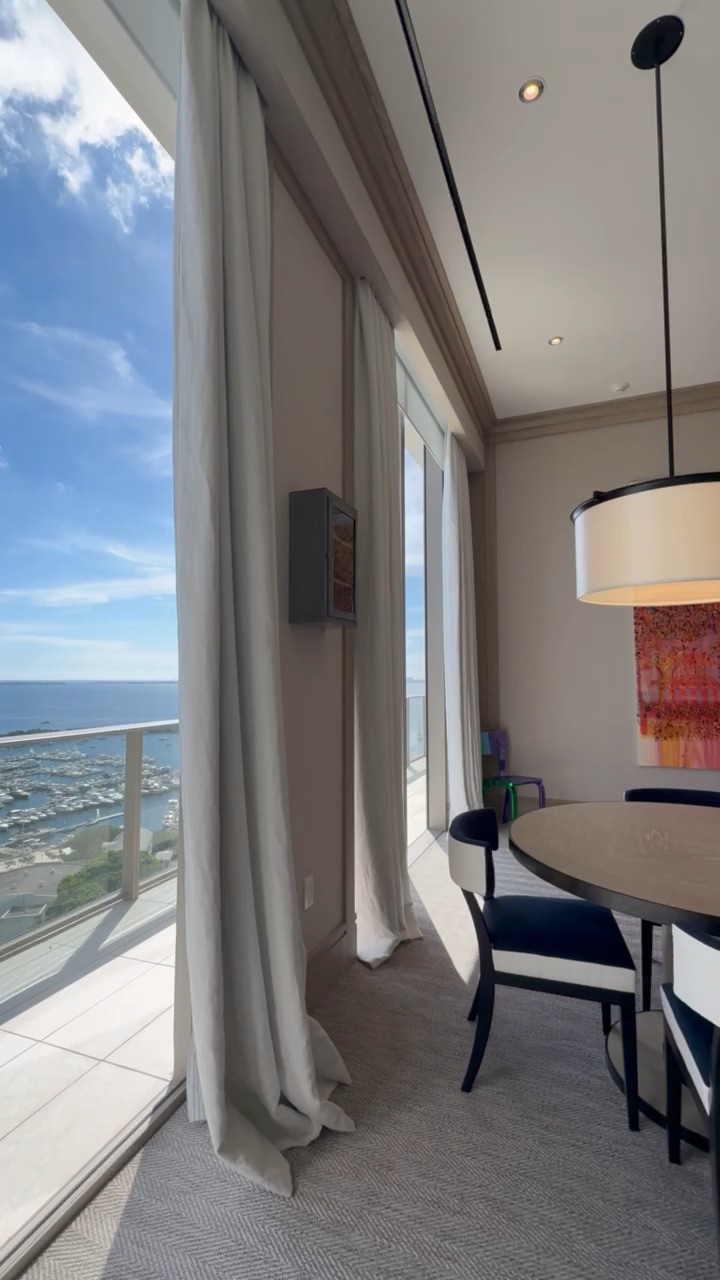 Floor-to-ceiling drapery framing a bay panorama